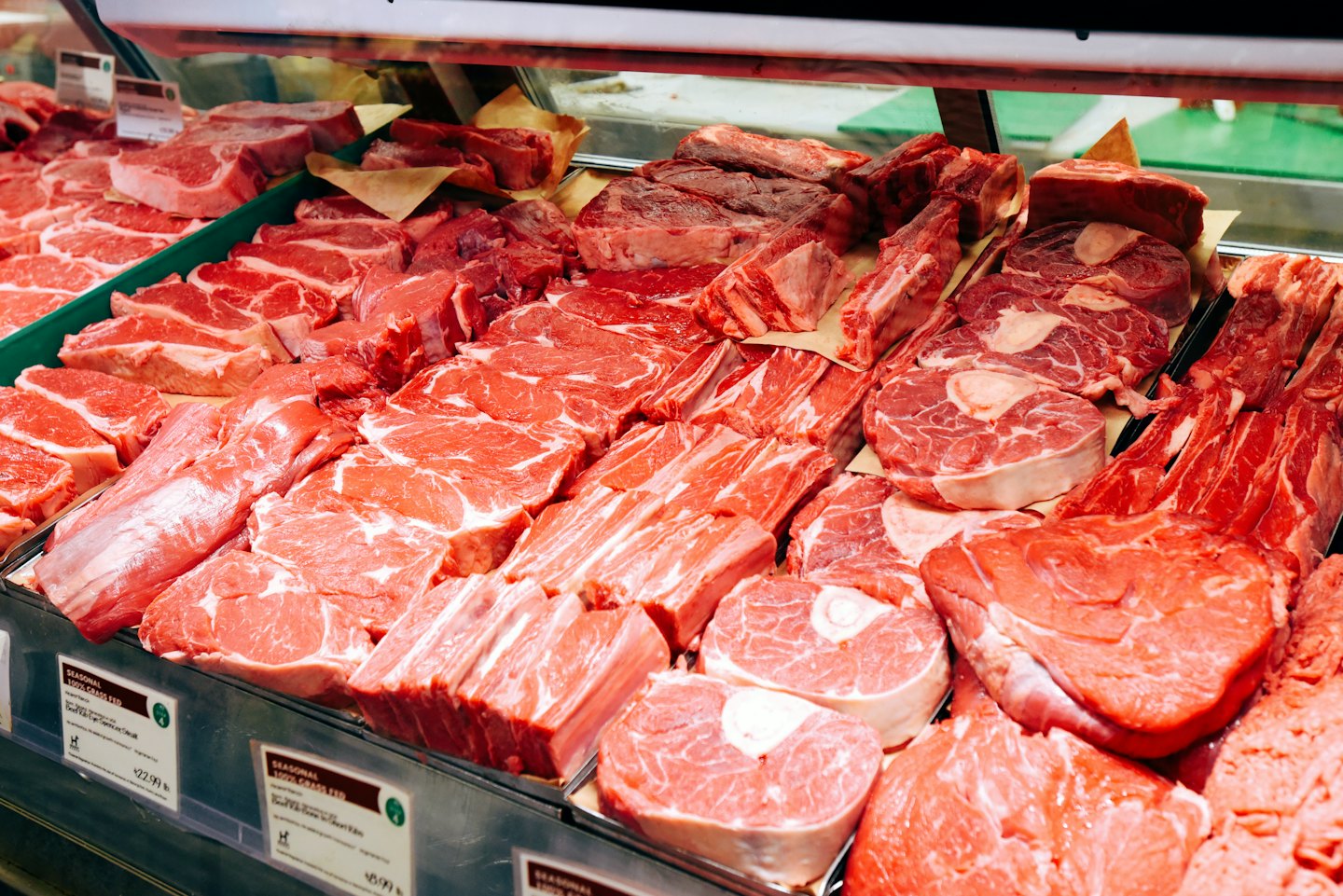 Fresh red meat cuts displayed in a refrigerated supermarket counter.